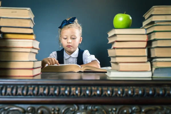 Intelligens iskola lány Olvasson egy könyvet a könyvtárban — Stock Fotó