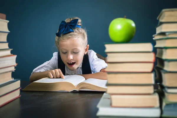 Intelligens iskola lány Olvasson egy könyvet a könyvtárban — Stock Fotó