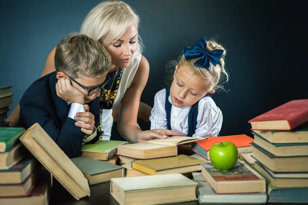 Μητέρα ή δάσκαλος βοηθώντας για τα παιδιά σχολείο που κάνει την εργασία, ανάγνωση — Φωτογραφία Αρχείου