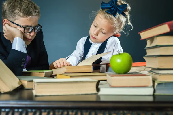 Skolbarnen läser en bok på biblioteket — Stockfoto