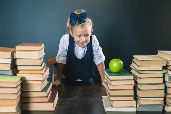 Χαριτωμένο κορίτσι σχολείο κάθεται στο τραπέζι με πολλά βιβλία — Φωτογραφία Αρχείου