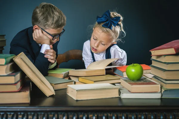 Skolbarnen läser en bok på biblioteket — Stockfoto