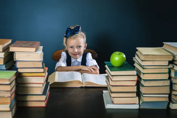 Closeup school girl sitting at the table with many books — Stock Photo, Image