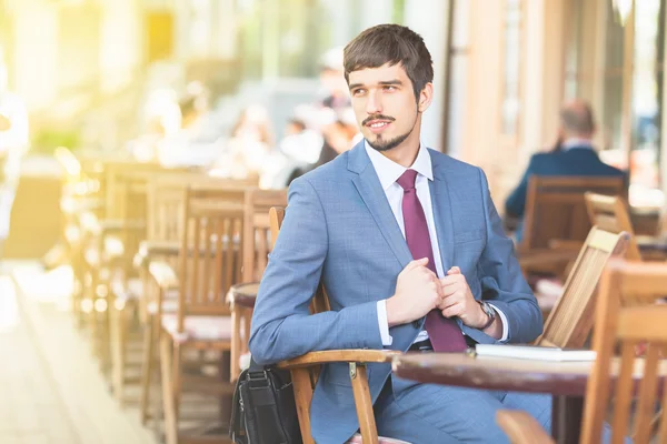 Handsome male has a french breakfast at sidewalk cafe outdors — Stock Photo, Image