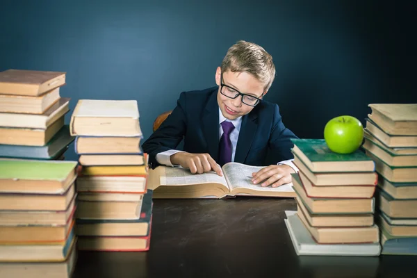 Smart School Boy liest ein Buch in der Bibliothek — Stockfoto