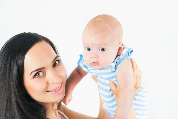 Mãe feliz segurando um menino no fundo branco — Fotografia de Stock