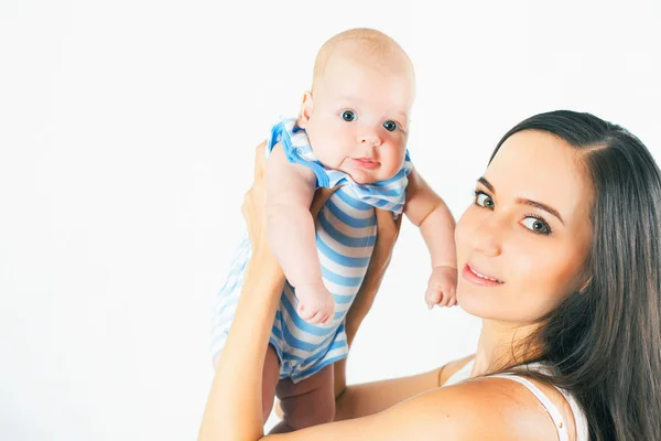 Mãe feliz segurando um menino no fundo branco — Fotografia de Stock