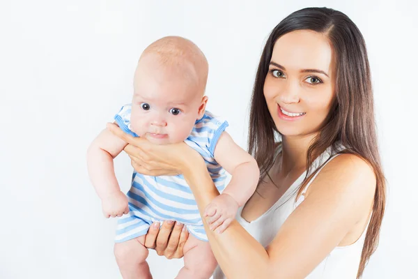 Mãe feliz segurando um menino no fundo branco — Fotografia de Stock