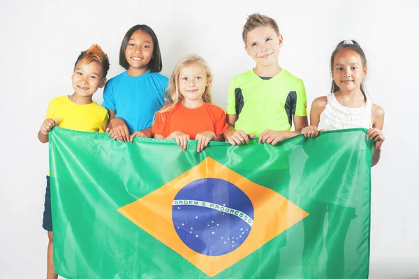 Grupo de crianças segurando uma bandeira do Brasil — Fotografia de Stock