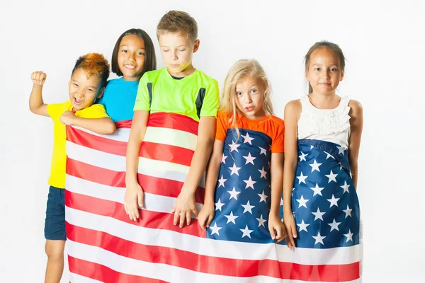 Grupa dzieci szkolnych posiadających amerykańską flagę narodową — Zdjęcie stockowe
