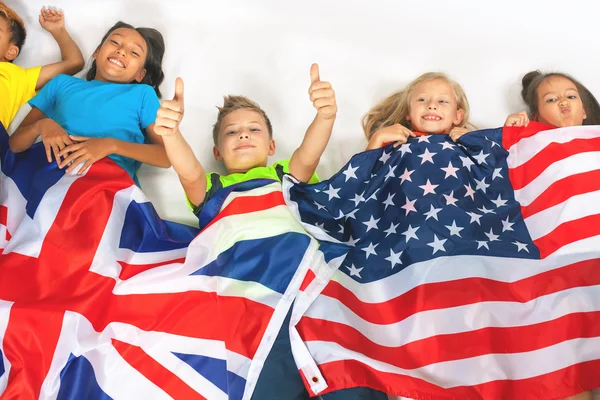 Ellerinde Büyük Britanya ve Amerika bayrakları taşıyan çocuklar