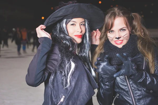 Oslava Halloweenu! ženy jako čarodějnické a kočičí role — Stock fotografie