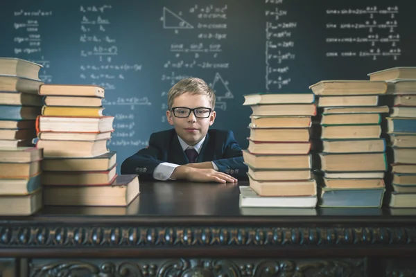 Rapaz da escola inteligente sentado à mesa — Fotografia de Stock