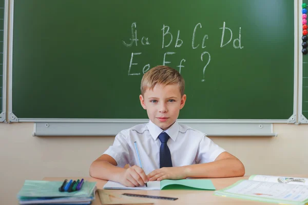 Schoolboy sits at a desk at school classroom — Φωτογραφία Αρχείου