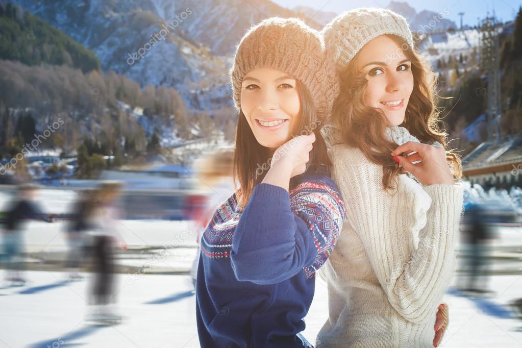 Group funny teenagers girls ice skating outdoor at ice rink