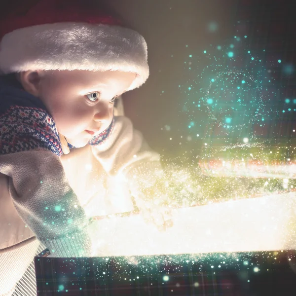 Cristmas baby holding gift with abstract fairy dust, stardust. Christmas — Stock Photo, Image