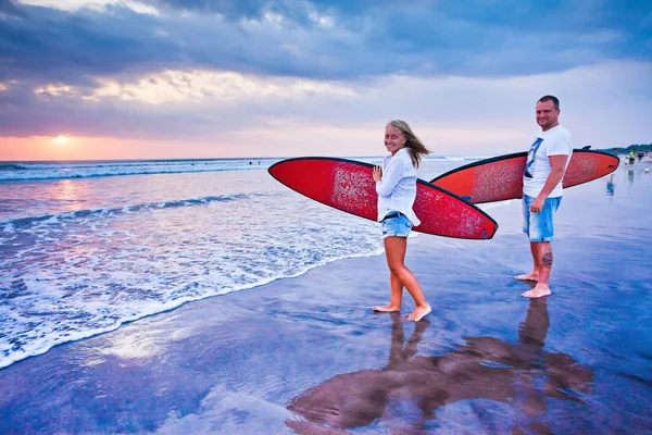 Pareja de surfistas caminando por la costa en Indonesia —  Fotos de Stock