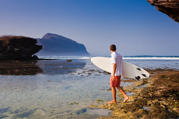 Surfista con tavola da surf su una costa — Foto Stock