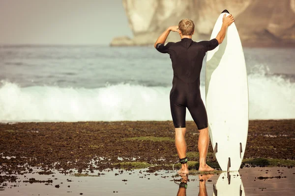 Surfer with surfboard on a coastline — Stock Photo, Image