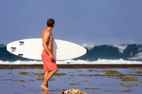 Surfista com prancha em um litoral — Fotografia de Stock