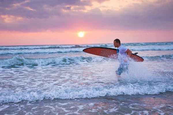 Surfista in esecuzione sulla costa in Indonesia — Foto Stock