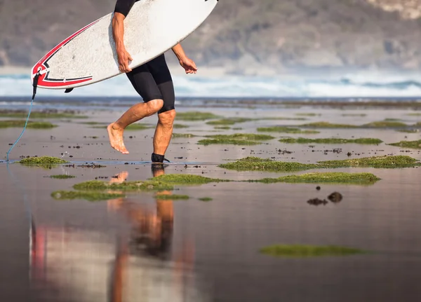 Surfista com prancha em um litoral — Fotografia de Stock