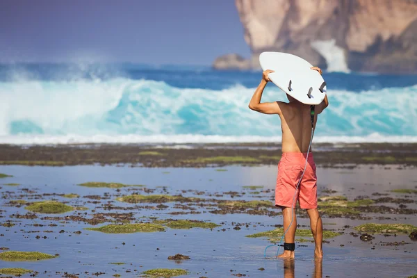 Hombre surfista con tabla de surf en una costa — Foto de Stock