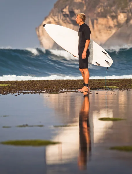 Surfista con tabla de surf en una costa —  Fotos de Stock