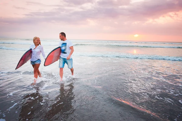 Couple of surfers walking on coast in Indonesia — Stock Photo, Image