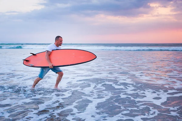 Surfer running on the beach — Stock Photo, Image