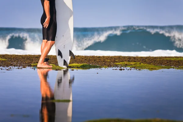 Surfista com prancha em um litoral — Fotografia de Stock