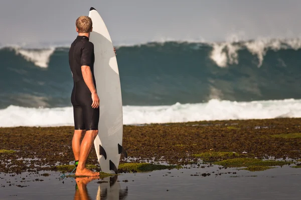 Surfista com prancha em um litoral — Fotografia de Stock