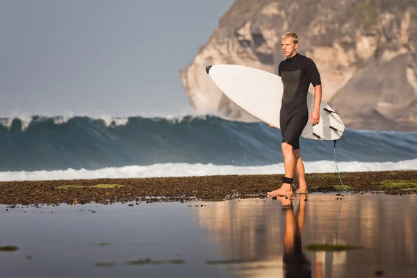 Surfista con tavola da surf su una costa — Foto Stock