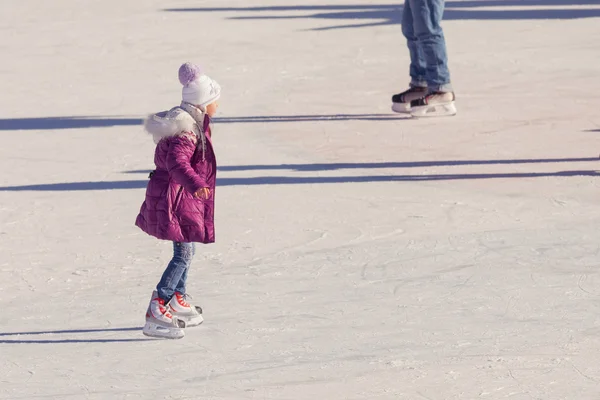 Petite fille en vêtements d'hiver patiner sur la patinoire — Photo