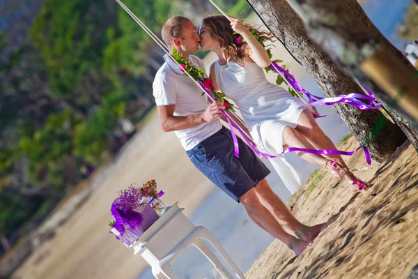 Casal de casamento montando em um balanço — Fotografia de Stock