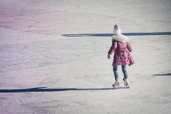 Meisje in winterkleren schaatsen op de ijsbaan — Stockfoto