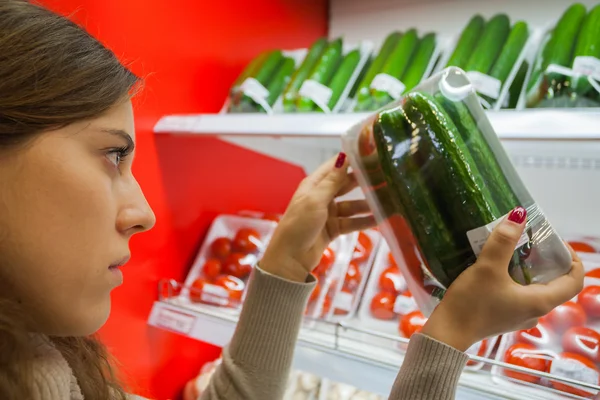 Packaged cucumber with woman hand in the supermarket — Stock Photo, Image