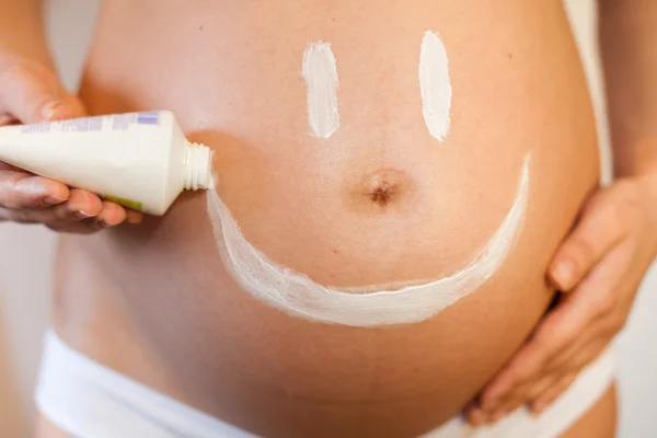 Mulher grávida com um sorriso no estômago — Fotografia de Stock