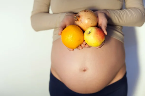 Mulher grávida segurando frutas — Fotografia de Stock