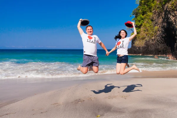 Heureux couple sautant à la plage — Photo