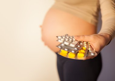 Pregnant woman uses vitamin tablets clipart