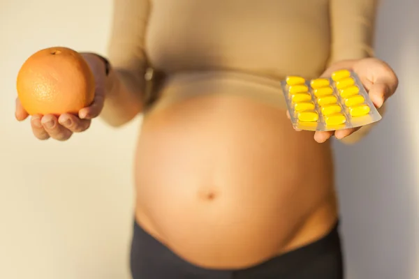 Mulher grávida usa comprimidos vitamínicos — Fotografia de Stock