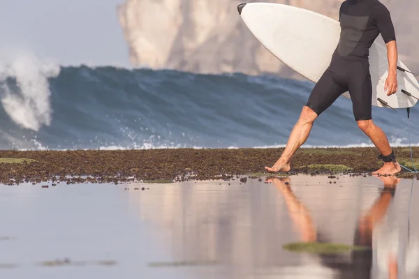 Surfista con tabla de surf en una costa —  Fotos de Stock