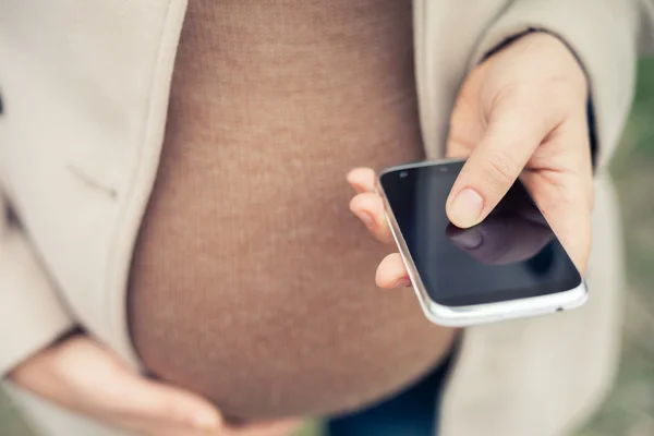 Mujer embarazada llamando por teléfono móvil —  Fotos de Stock