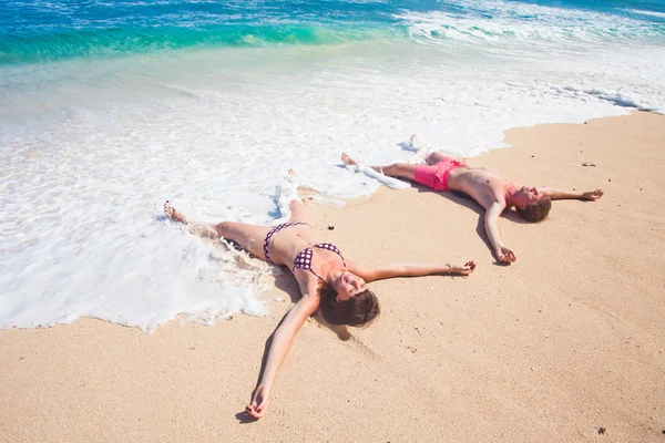 Par ligga på stranden — Stockfoto