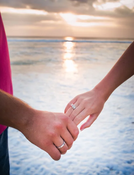 Holding hands at sea background — Stock Photo, Image