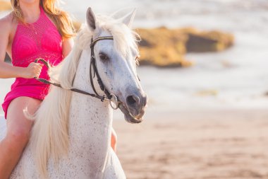 Genç bir kadın ata biniyor