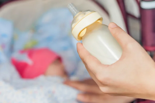 Happy mom holding baby bottle — Stock Photo, Image