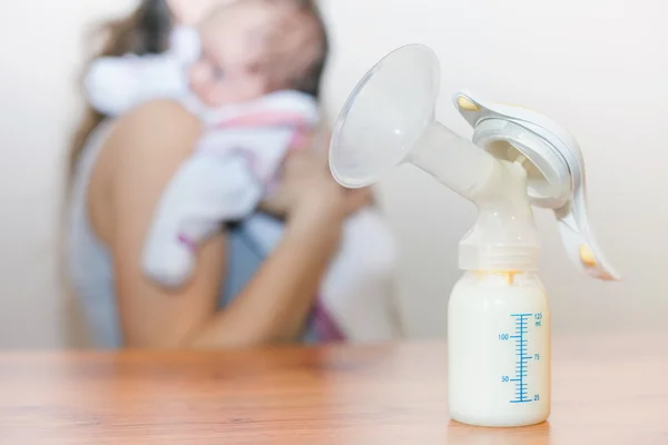 Manual breast pump and milk at background — Stock Photo, Image