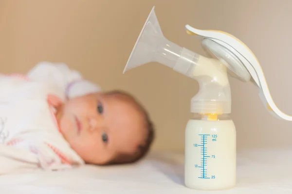 Manual breast pump and milk at background — Stock Photo, Image